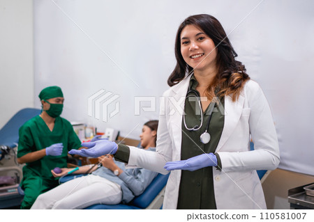 young female doctor smiling with hand gesture presenting something young female doctor smiling with hand gesture presenting something 110581007