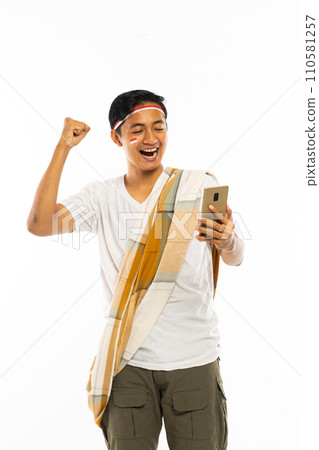 a handsome man with shoulder belt standing look at the phone a handsome man with shoulder belt standing look at the phone 110581257