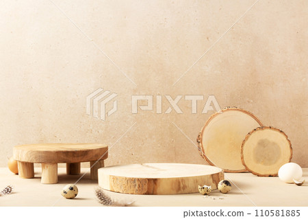 Empty round wooden podiums, quail eggs with green eucalyptus branches on a beige background. Empty round wooden podiums, quail eggs with green eucalyptus branches on a beige background. 110581885