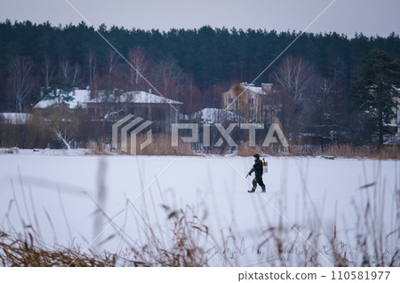 Winter landscape, fishermen on the ice of the lake. Ice fishing. Winter fishing as hobby Winter landscape, fishermen on the ice of the lake. Ice fishing. Winter fishing as hobby 110581977
