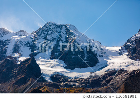 Snow-capped mountains rise majestically along the horizon Snow-capped mountains rise majestically along the horizon 110581991