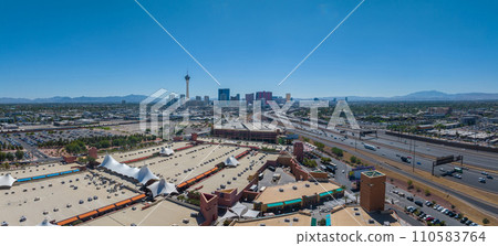 Aerial view of Las Vegas cityscape featuring the iconic Stratosphere Tower, diverse architecture, bustling roads, and green spaces against a mountainous backdrop in clear daylight. Aerial view of Las Vegas cityscape featuring the iconic Stratosphere Tower, diverse architecture, bustling roads, and green spaces against a mountainous backdrop in clear daylight. 110583764