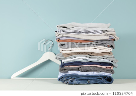 stack of folded clothes, blue background 110584704