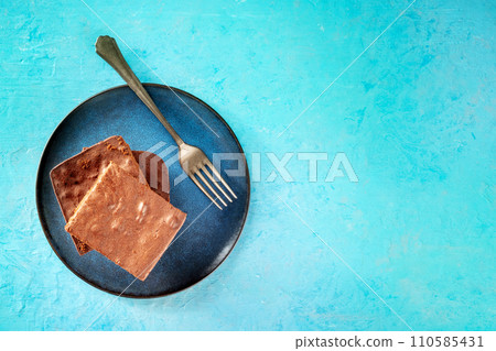 Chocolate brownie, simple coffee cake, overhead flat lay shot on blue 110585431