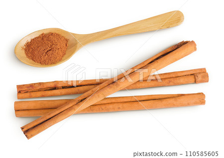 Cinnamon sticks with powder in wooden spoon isolated on white background with full depth of field. Top view. Flat lay. Cinnamon sticks with powder in wooden spoon isolated on white background with full depth of field. Top view. Flat lay. 110585605