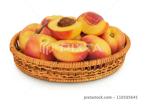 Ripe nectarine fruit with half in a wicker basket isolated on white background with full depth of field 110585645