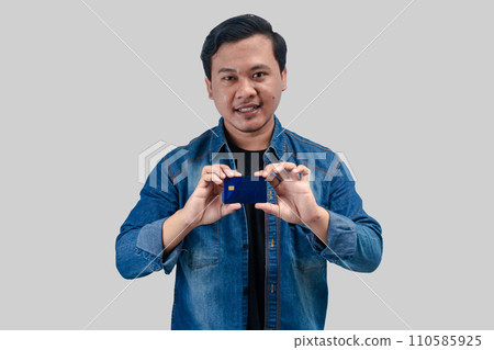 Young Asian Man shows his credit bank card Young Asian Man shows his credit bank card 110585925