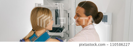 Smiling doctor prepairing woman before doing mammogram x-ray to check for breast cancer at hospital Smiling doctor prepairing woman before doing mammogram x-ray to check for breast cancer at hospital 110586227