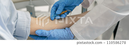 Close-up of doctor putting an IV drip to patient intravenously in hospital ward 110586278