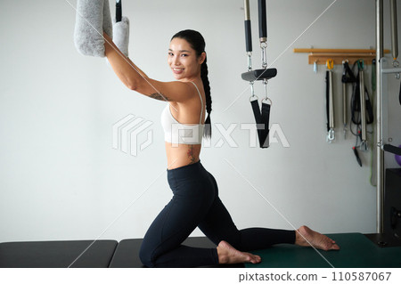 Portrait of slim fit young woman exercising in sports studio 110587067
