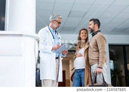 Pregnant woman and husband talking to obstetrician in hospital. Admitting woman in labor to maternity ward, planned cesarean section delivery. Pregnant woman and husband talking to obstetrician in hospital. Admitting woman in labor to maternity ward, planned cesarean section delivery. 110587885