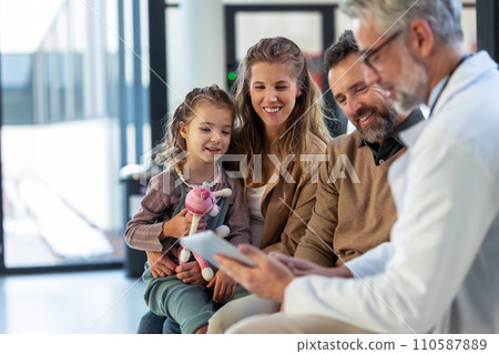 Doctor explaining results of MRI scan of brain to parents of young girl patient, delivering good news. Diagnosis of diseases and head injuries. 110587889