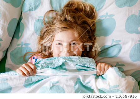 Cute little toddler girl sleeping in bed. Adorable preschool child dreaming, healthy sleep of children by day. Deep sleeping of toddler. Kids resting. Cute little toddler girl sleeping in bed. Adorable preschool child dreaming, healthy sleep of children by day. Deep sleeping of toddler. Kids resting. 110587910