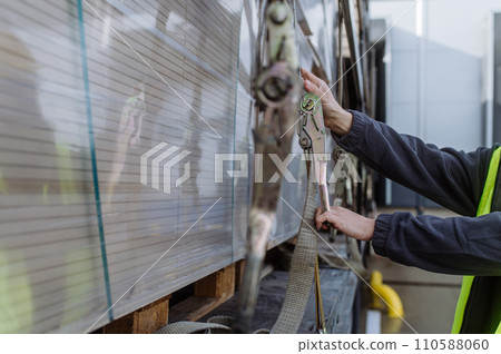 Warehouse receivers unloading of the truck in front of warehouse, checking delivered items. 110588060
