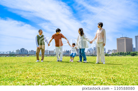 Three generations of a close family walking hand in hand Three generations of a close family walking hand in hand 110588080