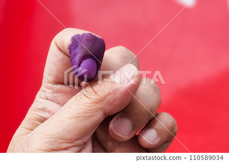 Closeup of purple indelible ink on index finger. Used in election in Malaysia to prevent fraud. Closeup of purple indelible ink on index finger. Used in election in Malaysia to prevent fraud. 110589034