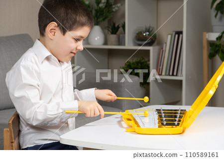 Little Six Year Old Boy Playing Metallophone Metal Xylophone Percussion Musical Instrument. 110589161