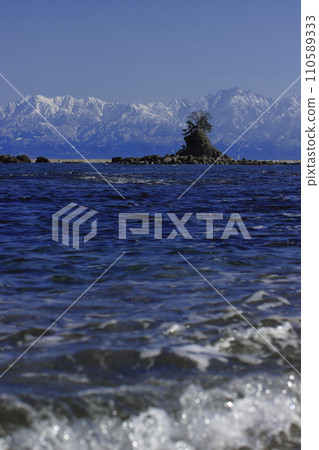 (Toyama Prefecture) Tateyama mountain range seen from the Amaharashi coast in winter 110589333