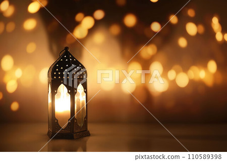 Dark silhouette of Moroccan lantern glowing at night. Glittering golden bokeh lights, blurred background. Ramadan Kareem, Eid ul Fitr muslim holiday still life. Festive celebration concept. Dark silhouette of Moroccan lantern glowing at night. Glittering golden bokeh lights, blurred background. Ramadan Kareem, Eid ul Fitr muslim holiday still life. Festive celebration concept. 110589398
