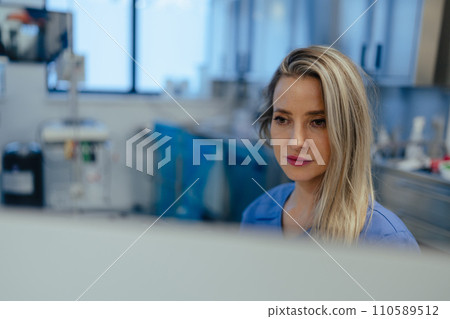 Portrait of ER doctor in hospital working in emergency room. Beautiful nurse making call and typing on medical computer in emergency room. 110589512