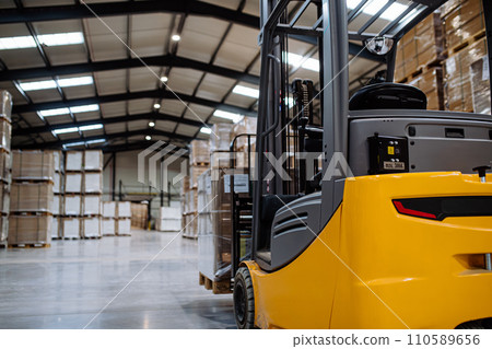 Back view of forklift in warehouse in the middle of stored goods.. Forklift driver preparing products for shipmennt, delivery, checking stock in warehouse. Back view of forklift in warehouse in the middle of stored goods.. Forklift driver preparing products for shipmennt, delivery, checking stock in warehouse. 110589656