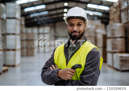 Warehouseman with scanner, scanning stock in warehouse. Warehouse manager using warehouse management software, app. 110589659