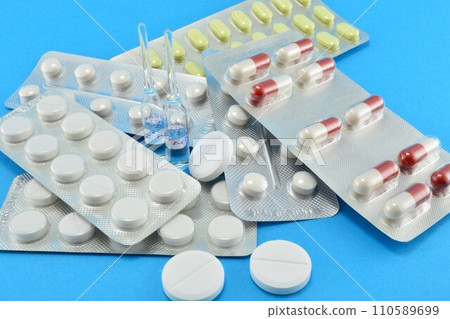 medicines, tablets and ampoules on a blue background 110589699