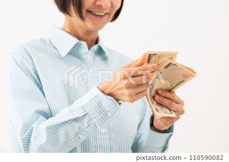 Middle-aged woman counting bills 110590082