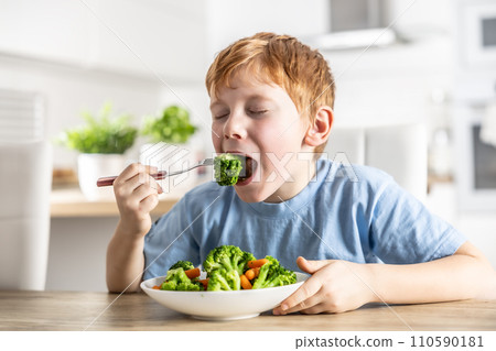 A little boy is having lunch and eating broccoli A little boy is having lunch and eating broccoli 110590181