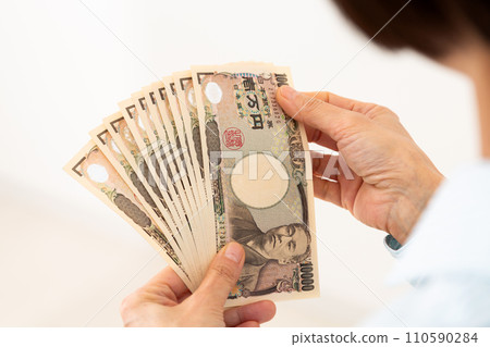 Hands of a middle-aged woman counting bills Hands of a middle-aged woman counting bills 110590284