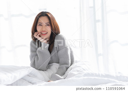 Stunning Beautiful Attractive Asian young woman sit on bed looking at camera and smile happiness and comfortable at home.Cute girl smile cross arm confident and relax in bed room Stunning Beautiful Attractive Asian young woman sit on bed looking at camera and smile happiness and comfortable at home.Cute girl smile cross arm confident and relax in bed room 110591064