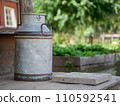 Image of milk churn at fresh green field against sunlight 110592541