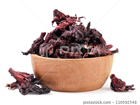 Hibiscus tea leaves in a wooden plate and scattered on a white background. Isolated Hibiscus tea leaves in a wooden plate and scattered on a white background. Isolated 110592548