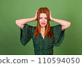 Young red hair woman on green background sad angry screaming crying 110594050