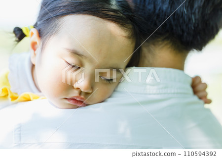 Cute little girl sleeping in her dad's arms 110594392