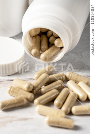 Food supplement pills in white plastic bottle. Capsules, collagen, vitamins, pain killers. Food supplement pills in white plastic bottle. Capsules, collagen, vitamins, pain killers. 110594884