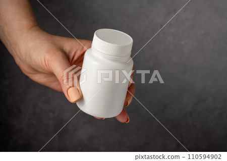 Antibiotics pills in white plastic bottle and glass of water. Capsules, collagen, vitamins, pain killers or drugs Antibiotics pills in white plastic bottle and glass of water. Capsules, collagen, vitamins, pain killers or drugs 110594902
