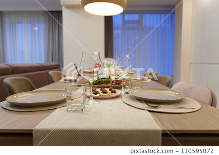 Table served for festive dinner in living room Table served for festive dinner in living room 110595072
