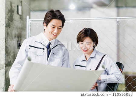 Construction staff checking the drawings at the construction site Construction staff checking the drawings at the construction site 110595083