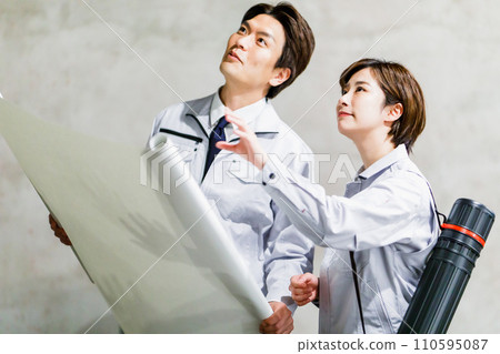 Construction staff checking the drawings at the construction site 110595087