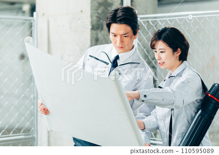 施工人員在施工現場檢查圖紙 110595089