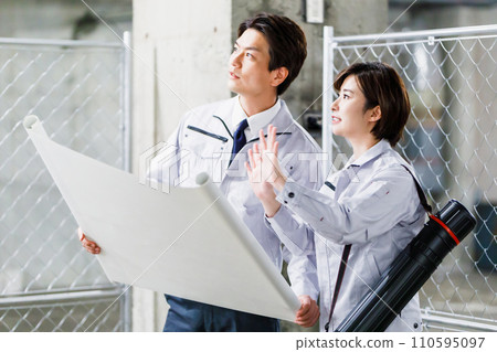 施工人員在施工現場檢查圖紙 110595097