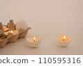 Easter holiday concept with different eggs and candles in eggshell in tray on white background. Quail and chicken eggs. Creative approach. Copy space 110595316