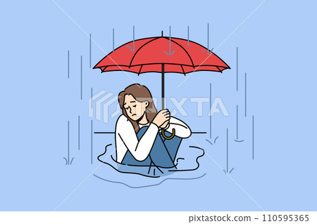 Woman sits in puddle in rain and holds umbrella over head, trying to escape autumn downpour 110595365