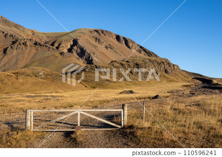 Field with a fence beside a mountain, east Iceland Field with a fence beside a mountain, east Iceland 110596241