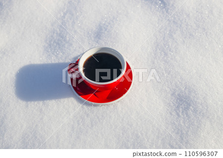 Red ceramic cup of espresso coffee on snow background of a winter landscape  110596307