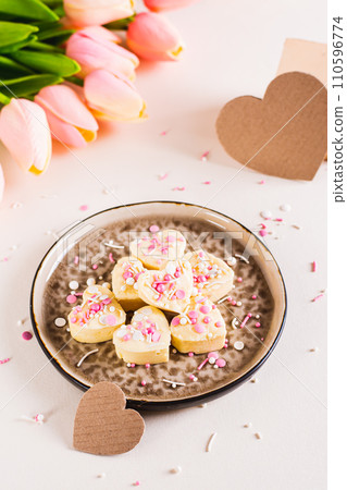 Homemade white chocolate candy hearts with icing on a plate on the table vertical view 110596774