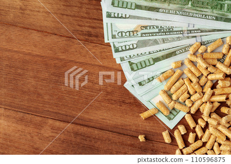 Dollar banknotes and wood pellets on wooden table Dollar banknotes and wood pellets on wooden table 110596875