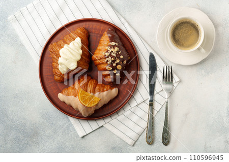 Glazed croissants on clay plate on table Glazed croissants on clay plate on table 110596945