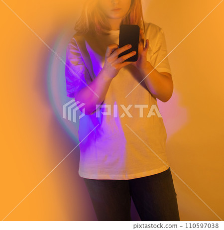 Happy woman holding a smartphone and receiving a new message  110597038
